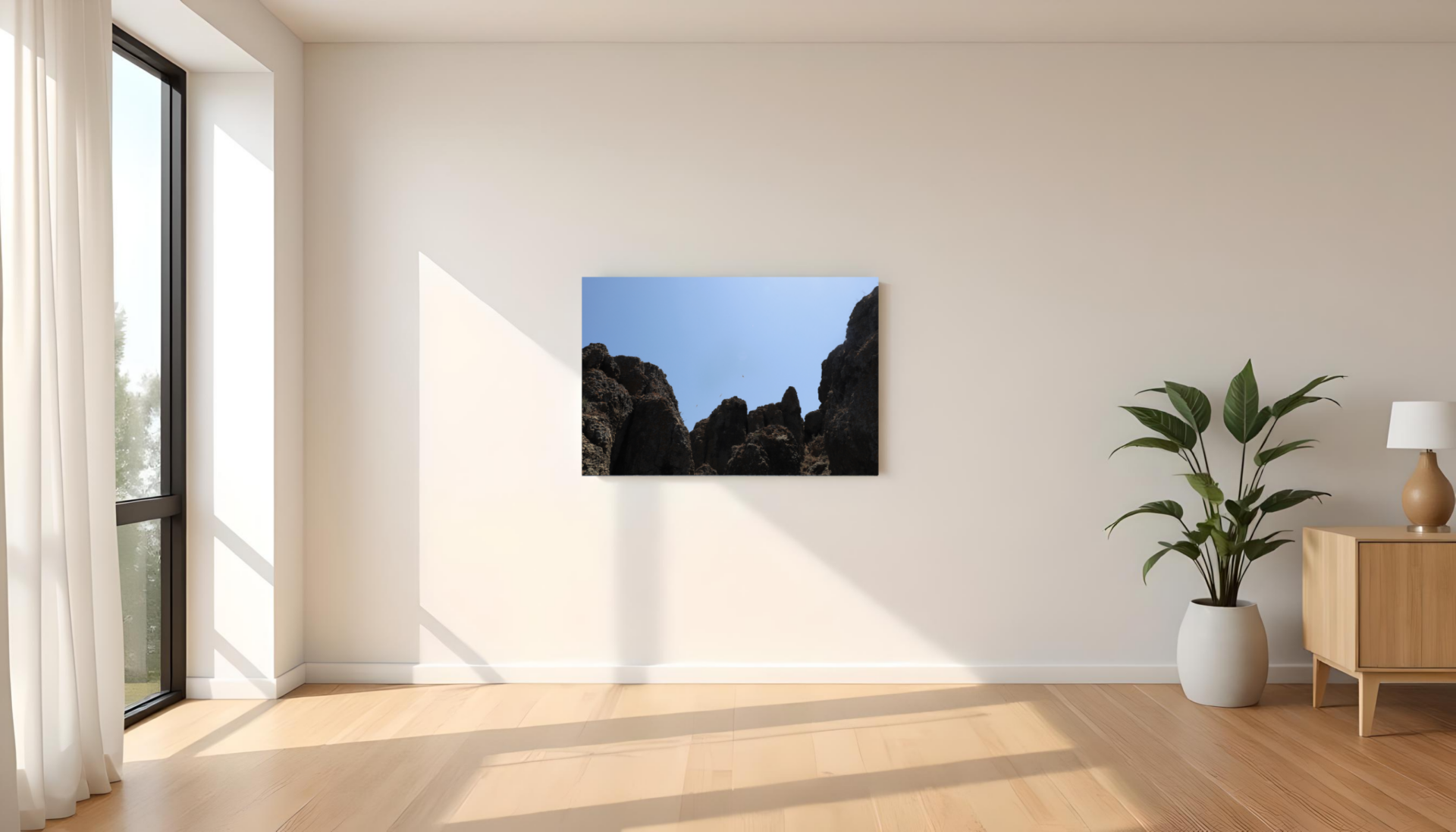 Obraz na płótnie przedstawiający skalne klify pod czystym niebem zawieszony w jasnym, minimalistycznym wnętrzu.